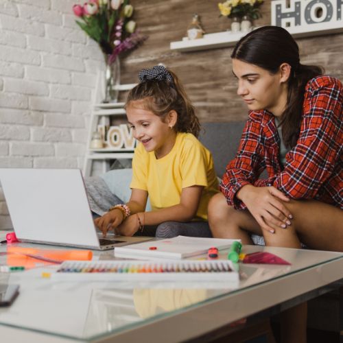 A mother and child working together at a laptop during homeschool time, reflecting a peaceful winter homeschool atmosphere.