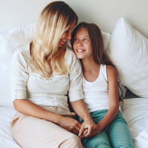 A mother and daughter sitting together on a bed, sharing a warm, peaceful moment that reflects after Christmas homeschool mother encouragement.